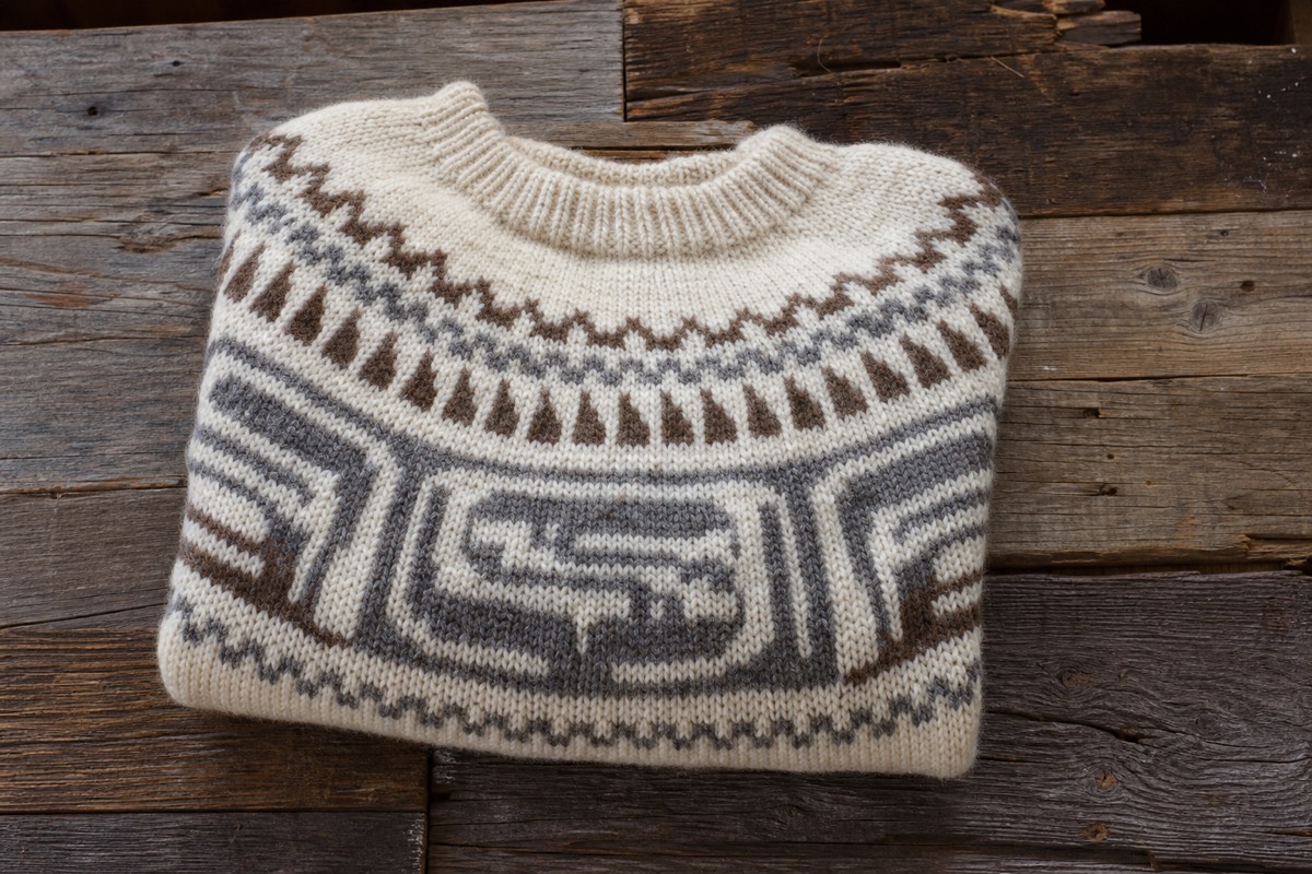 A thick hand-knit Cowichan sweater in natural cream, grey and brown wool with a figured geometric pattern